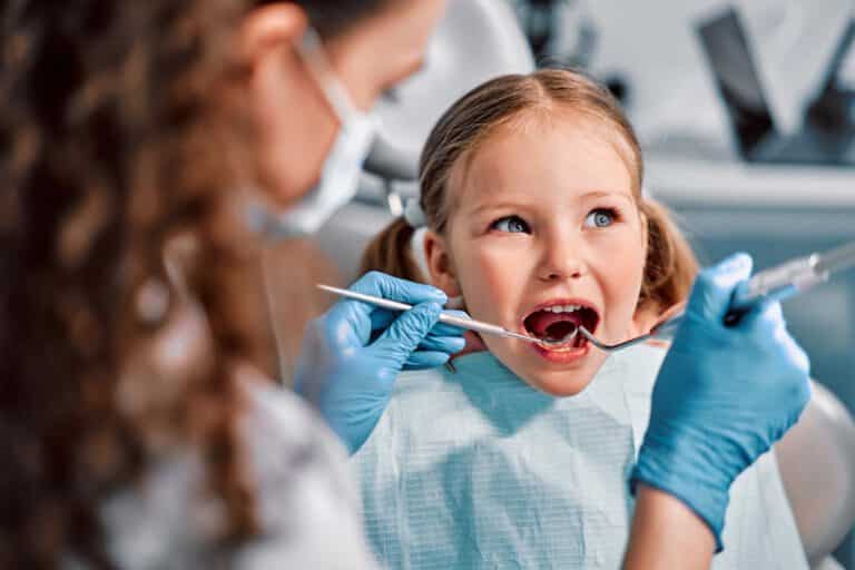 Enfant souriant au fauteuil dentaire