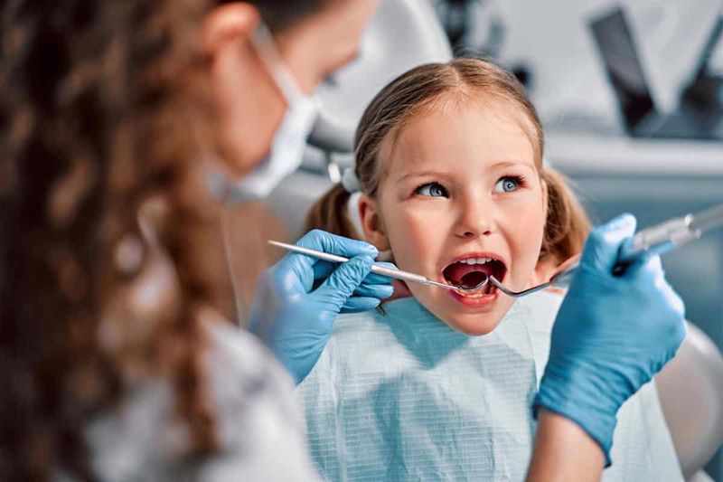 Enfant souriant au fauteuil dentaire